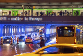 The main train station in Essen, blue illuminated underpass, bus station, am Europaplatz, train on