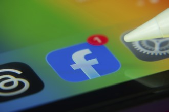 16 Nov 2025- Dhaka, Bangladesh: Stylus touching the Facebook app icon with a notification on a