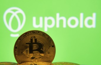 Dhaka, Bangladesh- 19 Sep 2025: Close-up of Bitcoin coins with the Uphold logo visible on a screen