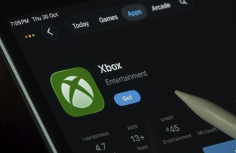 Dhaka, Bangladesh- 30 Oct 2025: Xbox app displayed on a iPad screen in dark mode with a digital pen