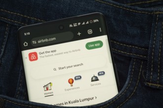 Dhaka, Bangladesh- 21 Nov 2025: A smartphone displaying the Airbnb web interface peeks out of a