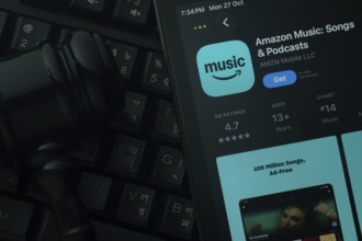 Dhaka, Bangladesh- 21 Nov 2025: An iPad displaying the Amazon Music app against a judge's gavel and