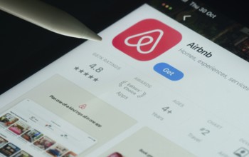 Dhaka, Bangladesh- 21 Nov 2025: Airbnb app on a iPad screen with a pen pointing at the install