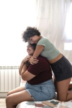 A loving couple enjoying a tender moment together in a sunlit room. They are smiling and gazing at