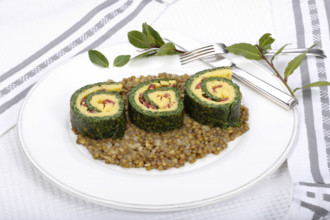 Southern German cuisine, polenta spinach roulade with alblentils served on serving platter, bay