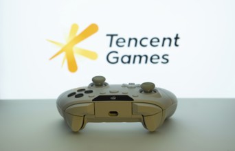 Dhaka, Bangladesh- 14 Nov 2025: A close-up of a white gamepad with the Tencent Games seen on screen