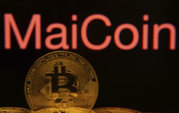 Dhaka, Bangladesh- 03 Sep 2025: Close-up of Bitcoin coins with the MaiCoin logo visible on a screen