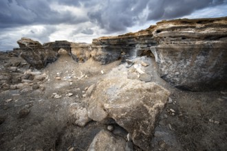 Eroded rock formations in volcanic landscape with dramatic cloudy skies, Ciudad Estratificada or