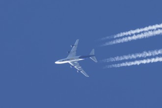 Boeing 747 jumbo jet cargo aircraft of Atlas air airlines flying in a blue sky with contrails or