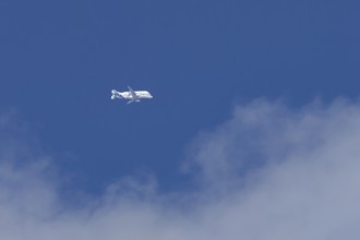 Airbus A330-743L Beluga XL cargo jet aircraft flying in a blue sky with white clouds, England,