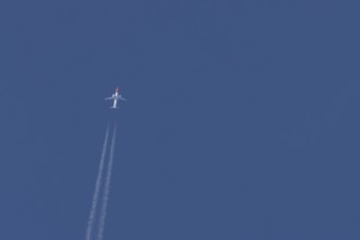 Boeing 737 jet passenger aircraft of Norwegian Air airlines flying in a blue sky with contrails or