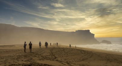 Tourists watch the waves of the Atlantic on the rocky plateau of Sito, also known as Forte São
