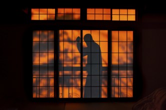 Shadow of a man, burglar with knife, assassin, ninja, on the balcony behind sliding shoji doors in