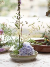 Floral art composition being created during an ikebana workshop using hydrangeas and other flowers