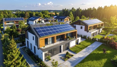 Aerial view showcases modern houses with solar panels and green roofs in a suburban setting,