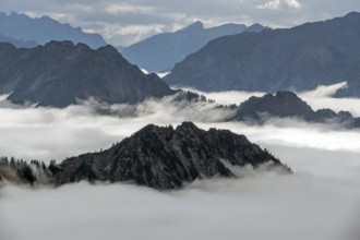 View from the Nebelhorn summit to mountains of the Allgäu Alps, mountains rising from fog in the