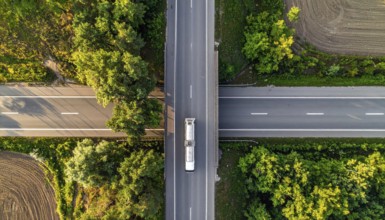 Petrol cargo truck lorry tanker driving on highway hauling oil products at sunrise, wide hilly