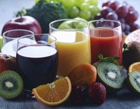 Fresh fruit juices in glasses, surrounded by colorful fruits, showcasing healthy drinking and