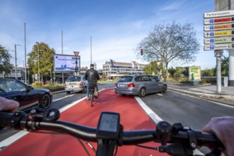 Riding a bike in a bike lane, marked in red to attract the attention of motorists, between 2 lanes,