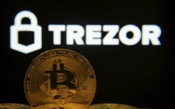 Dhaka, Bangladesh- 30 Sep 2025: Close-up of Bitcoin coins with the Trezor logo visible on a screen
