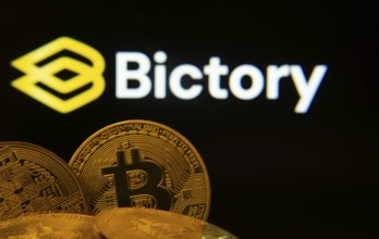 Dhaka, Bangladesh- 09 Sep 2025: Close-up of Bitcoin coins with the Bictory logo visible on a screen