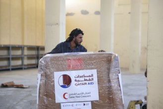Relief workers unload boxes of medical aid provided by Qatar at Damascus International Airport,