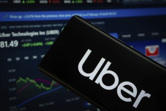 Dhaka, Bangladesh- 15 July 2025: Uber logo is displayed on a smartphone screen, with a stock graph