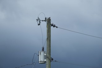 Electric pole with wires set against a cloudy, overcast sky, Gazipur, Bangladesh