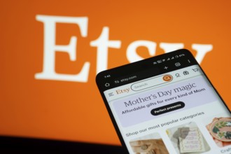 Dhaka, Bangladesh- 03 July 2025: Smartphone displaying Etsy web interface against Etsy logo