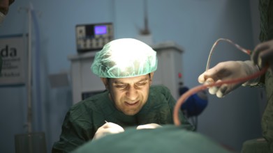 Several doctors performing a complex surgical operation inside an operating room for a displaced