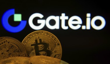 Dhaka, Bangladesh- 08 Aug 2025: Close-up of Bitcoin coins with the Gate.io logo visible on a screen