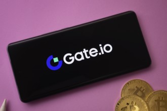Dhaka, Bangladesh- 22 June 2025: Gate.io logo on smartphone screen near Bitcoin coin and QR code on