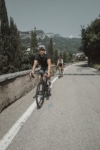 Woman and man cycling on Lake Garda in Italy. Sunny weather and dolce vita