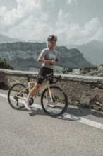 Young woman riding a racing bike on Lake Garda. Sunny weather and dolce vita
