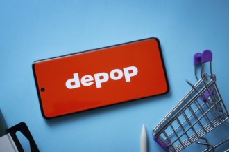 Dhaka, Bangladesh- 03 July 2025: Smartphone displaying Depop logo with shopping cart on a blue