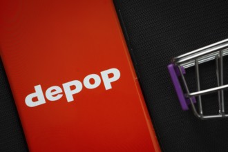 Dhaka, Bangladesh- 03 July 2025: A smartphone displaying the Depop logo next to a miniature