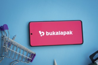 Dhaka, Bangladesh- 03 July 2025: Smartphone displaying Bukalapak logo with shopping cart on a blue