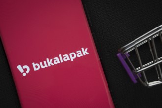 Dhaka, Bangladesh- 03 July 2025: A smartphone displaying the Bukalapak logo next to a miniature