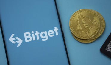 Dhaka, Bangladesh- 22 July 2025: Bitget logo on smartphone screen near Bitcoin coin and QR code on