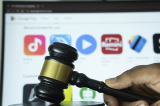 Dhaka, Bangladesh- 20 June 2025: A hand holds a gavel in front of a computer screen displaying