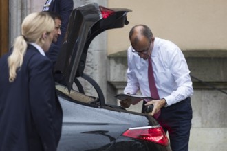 Friedrich Merz (CDU, German Chancellor) takes something out of a car boot in front of the joint