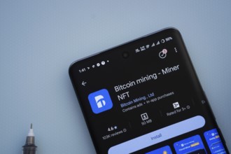 Dhaka, Bangladesh- 29 May 2025: On a blue surface, a smartphone displays the Bitcoin mining app