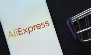 Dhaka, Bangladesh- 03 July 2025: A smartphone displaying the AliExpress logo next to a miniature