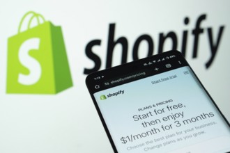 Dhaka, Bangladesh- 03 July 2025: Smartphone displaying Shopify web interface against Shopify logo