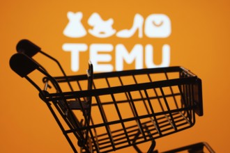 Dhaka, Bangladesh- 03 July 2025: Silhouette of a shopping cart in front of the Temu logo,