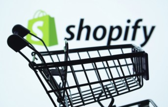 Dhaka, Bangladesh- 03 July 2025: Silhouette of a shopping cart in front of the Shopify logo,