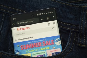 Dhaka, Bangladesh- 15 June 2025: A smartphone displaying the AliExpress web interface peeks out of