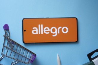 Dhaka, Bangladesh- 03 July 2025: Smartphone displaying Allegro logo with shopping cart on a blue