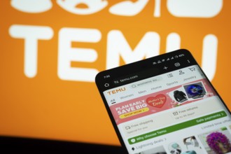 Dhaka, Bangladesh- 03 July 2025: Smartphone displaying Temu web interface against Temu logo