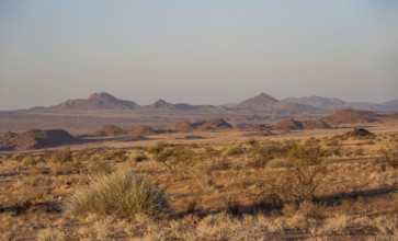 Desert landscape in the evening light at sunset, barren landscape with hills of stacked rocks,
